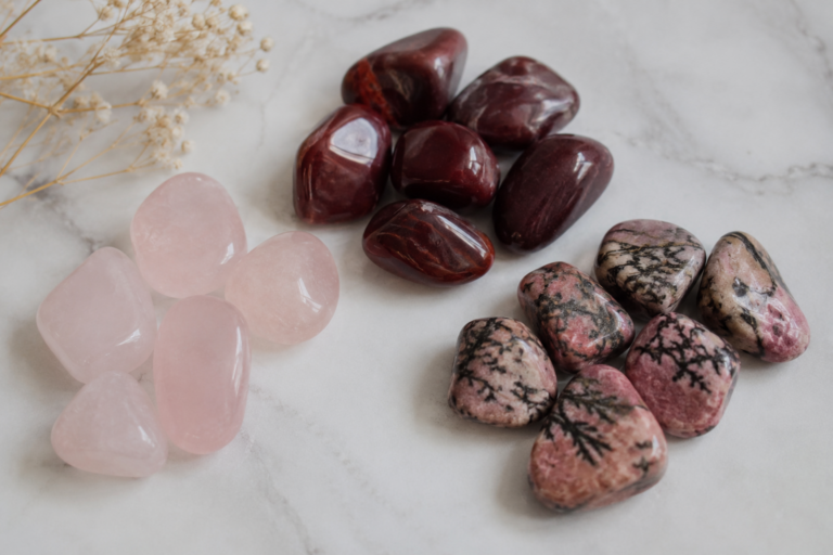 Piedras para el amor: rodados de cuarzo rosa a la izquierda, rodados de granate en el centro y rodados de rodonita a la derecha. Todo sobre fondo blanco